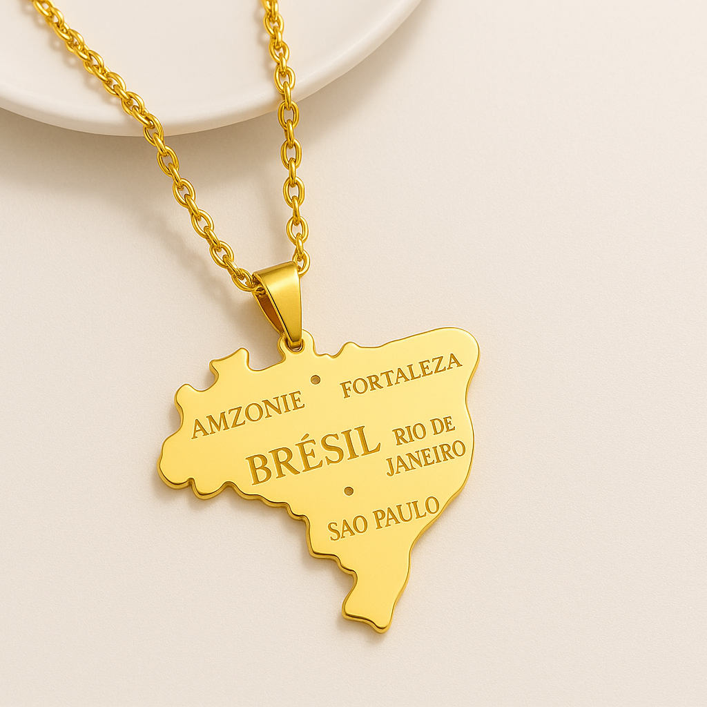 Brasilien Karten Anhänger in Gold – Nahaufnahme mit gravierten Städten São Paulo Rio de Janeiro Fortaleza Amazonas auf beigem Untergrund