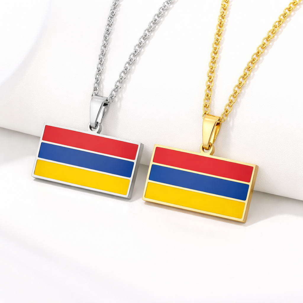 Zwei Halsketten mit armenischem Flaggen-Anhänger in den Landesfarben Rot, Blau und Gelb – einmal in Gold und einmal in Silber – auf hellem Hintergrund