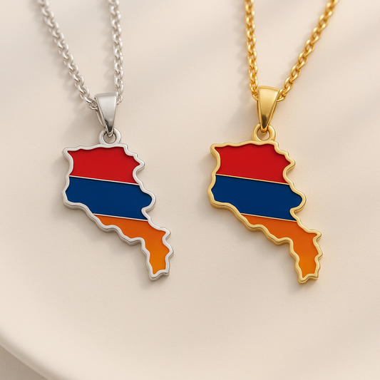 Zwei Halsketten mit Armenien-Karten-Anhänger in den Landesfarben Rot, Blau und Orange – einmal in Gold und einmal in Silber – auf hellem Hintergrund