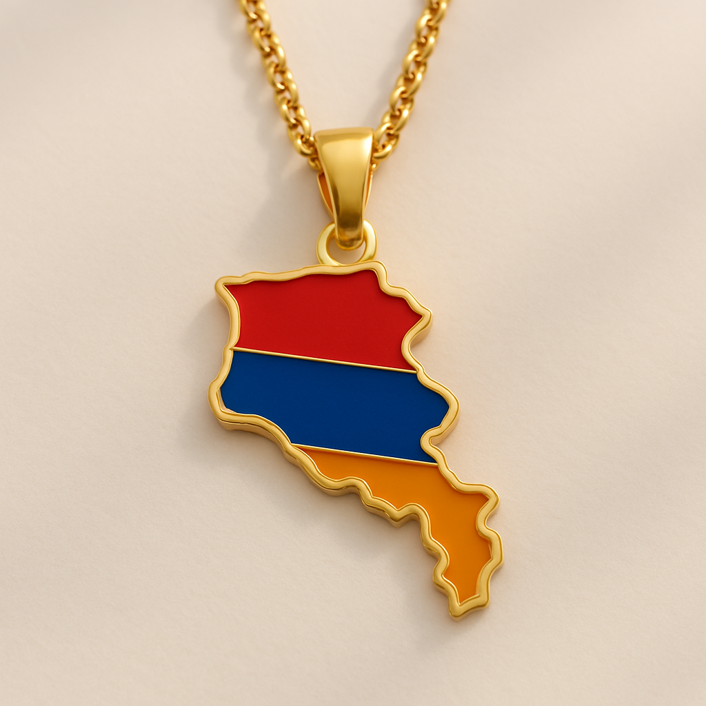 Goldene Halskette mit Armenien-Karten-Anhänger in den Landesfarben Rot, Blau und Orange, auf hellem Hintergrund liegend
