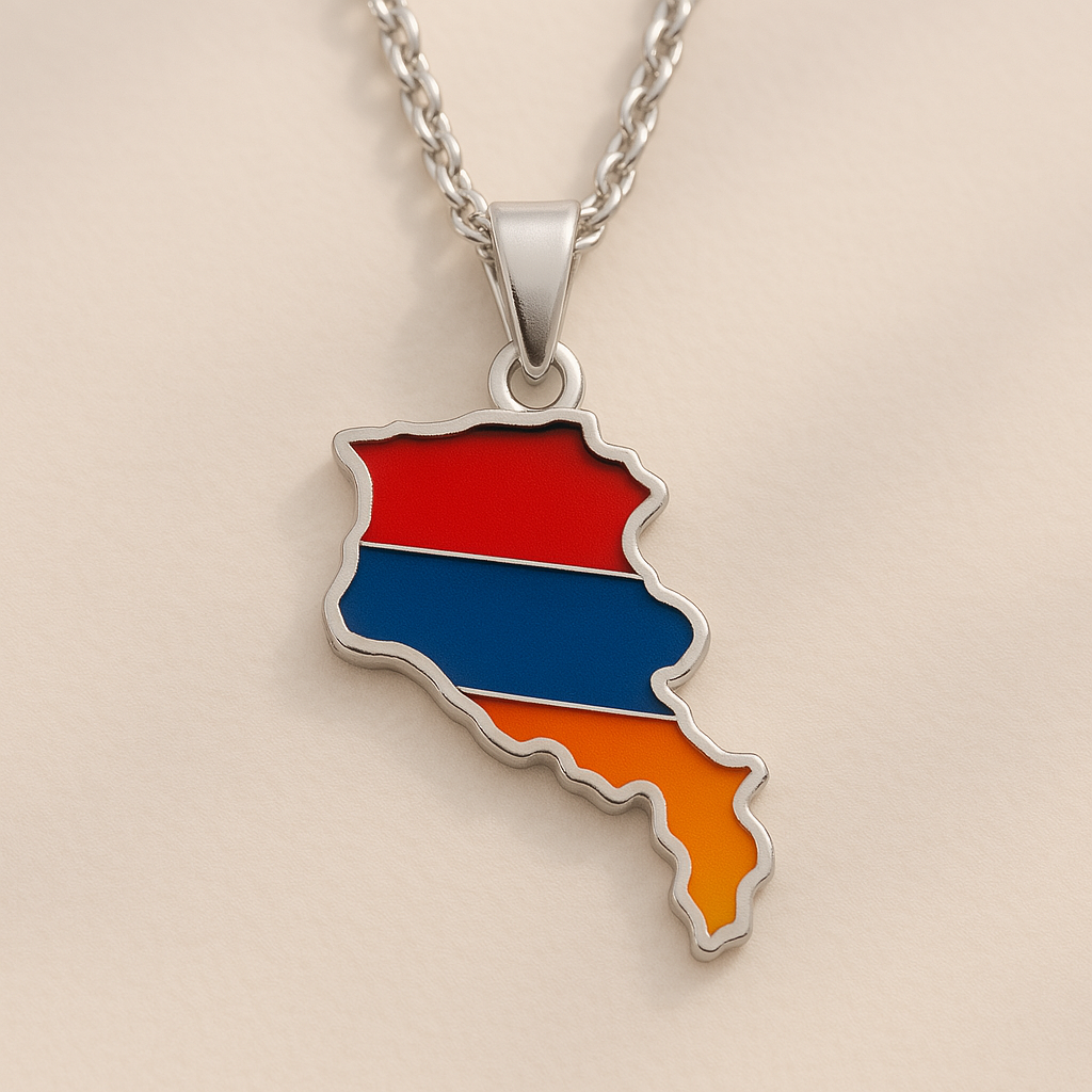 Silberne Halskette mit Armenien-Karten-Anhänger in den Landesfarben Rot, Blau und Orange, auf hellem Hintergrund liegend
