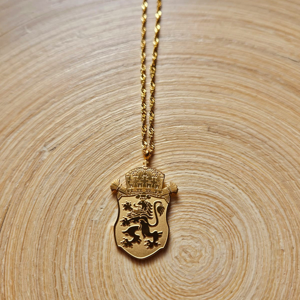 Goldene Bulgarien Wappen Halskette aus Edelstahl mit Löwen Anhänger im minimalistischen Design auf hellem Holzuntergrund.