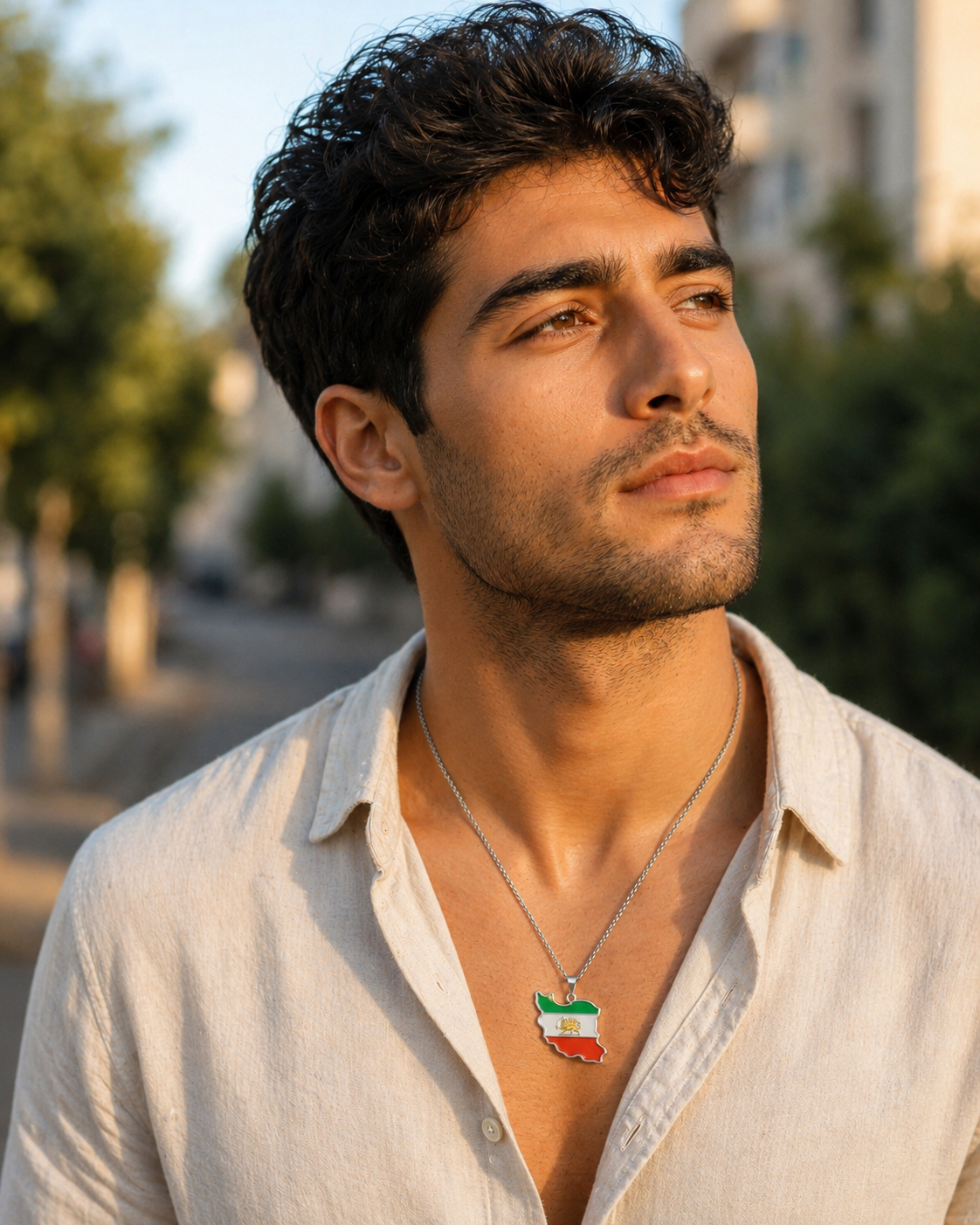 Schlichte silberne Iran-Karten-Halskette aus Edelstahl – getragen von einem jungen Mann im weißen Leinenhemd, Outdoor-Porträt bei Sonnenuntergang