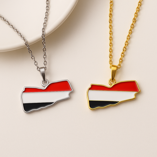 Zwei Jemen-Karten-Halsketten aus Edelstahl in den Nationalfarben Rot, Weiß und Schwarz – eine mit silberner und eine mit goldener Kette – nebeneinander auf hellem Hintergrund