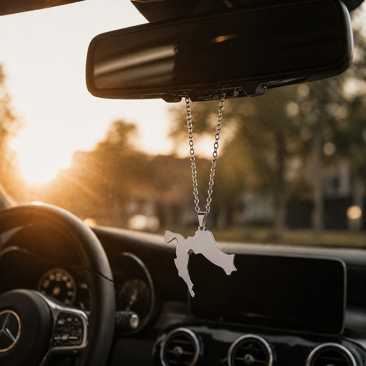 Kroatien Kette aus Edelstahl hängt am Rückspiegel eines Autos bei Sonnenuntergang