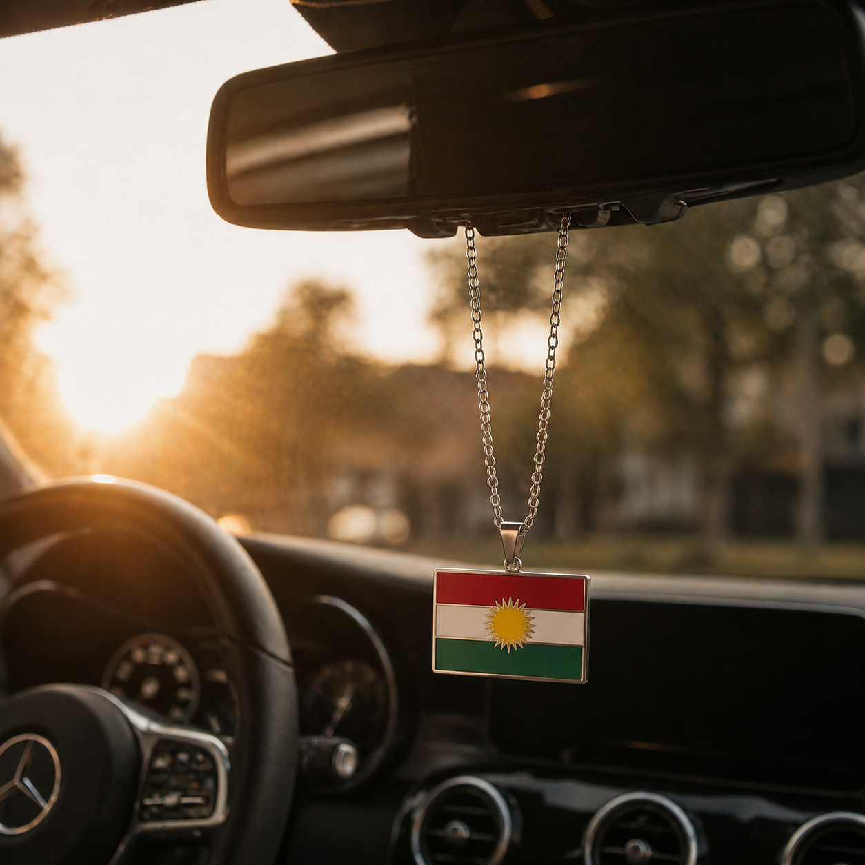 Kurdistan-Flaggenanhänger aus Edelstahl in Silber, rechteckig, am Rückspiegel eines Mercedes befestigt, Sonnenuntergangsstimmung im Auto