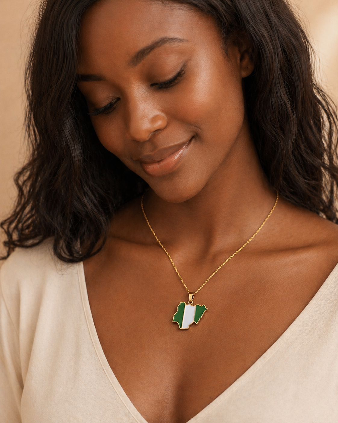 Nigeria Karte Flagge Halskette in Gold – lächelnde Frau trägt Anhänger mit grün-weißer nigerianischer Flagge in Landkartenform im Sonnenlicht