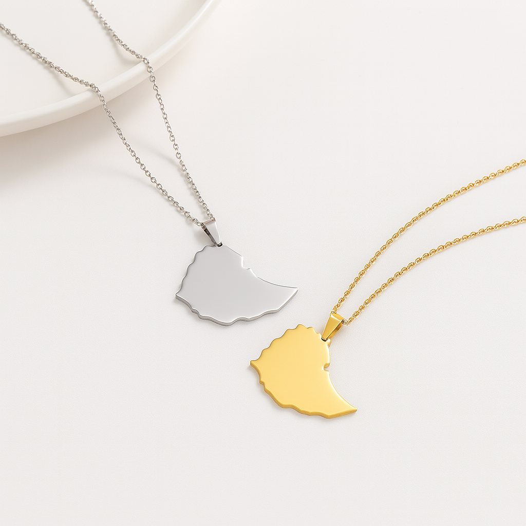 Zwei schlichte Äthiopien-Karten-Halsketten aus Edelstahl – eine in Silber und eine in Gold – nebeneinander auf weißem Hintergrund