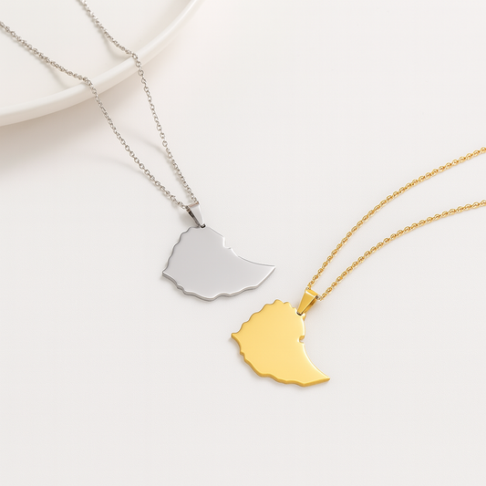 Zwei schlichte Äthiopien-Karten-Halsketten aus Edelstahl – eine in Silber und eine in Gold – nebeneinander auf weißem Hintergrund